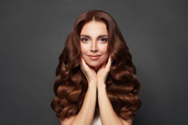 Uzun kıvırcık saçlı, güzel, neşeli bir kadın. Muhteşem bir model. 