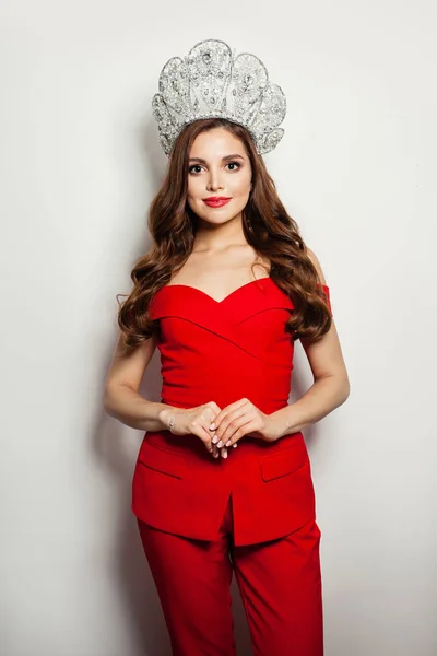 Krásná modelka žena v červeném obleku a diamantové koruně stojící — Stock fotografie