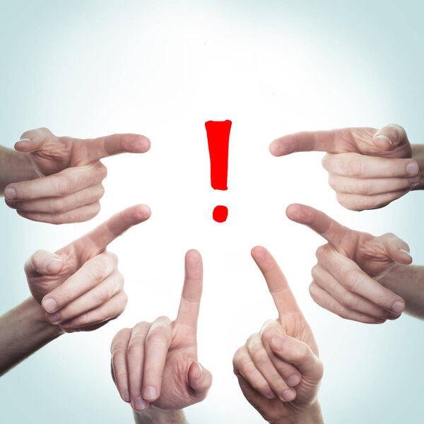 Many hands point to a Exclamation sign. Concept attention 