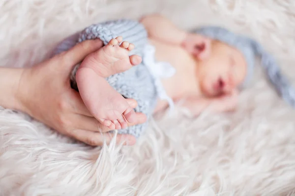 Pequenas pernas de bebê nas mãos dos pais — Fotografia de Stock