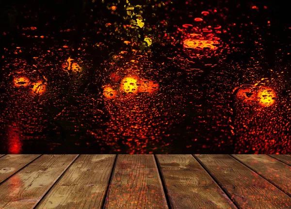Gotas de lluvia en la superficie de vidrio con luces rojas bokeh noche de la ciudad — Foto de Stock
