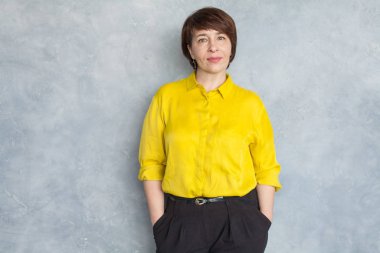 Sarı gömlek giyen zeki bir iş kadını. Olgun kadın 45 yaşında.