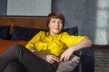 Orta yaşlı kadın evde dinleniyor.
