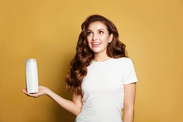 Happy woman looking up and holding white empty shampoo tube — ストック写真