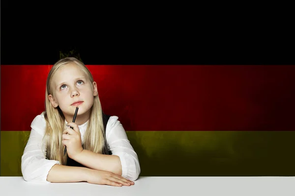 Pensando niña estudiante contra el fondo de la bandera de Alemania . — Foto de Stock