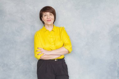 Sarı gömlekli mutlu iş kadını gülümsüyor. 