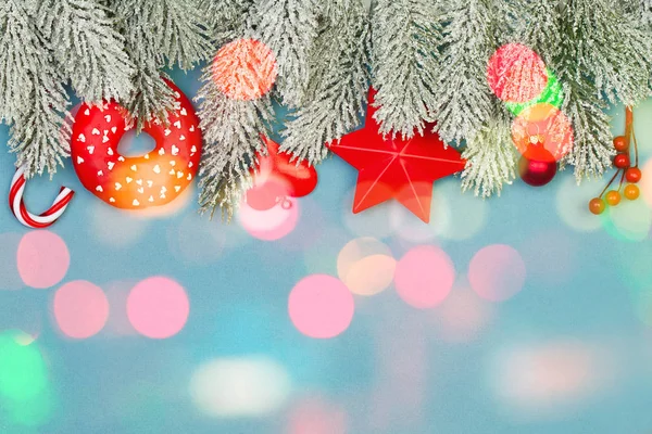 雪のモミの枝を持つクリスマスの背景とカラフルなボケ — ストック写真