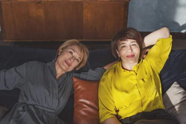 Två kvinnor kopplar av och ler hemma — Stockfoto