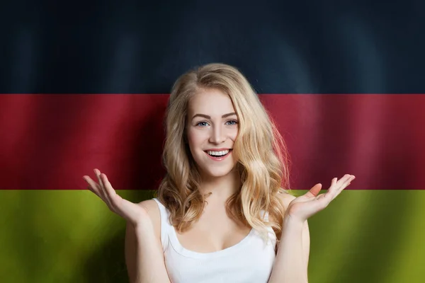 Hermosa mujer joven feliz contra el fondo de la bandera de Alemania . — Foto de Stock