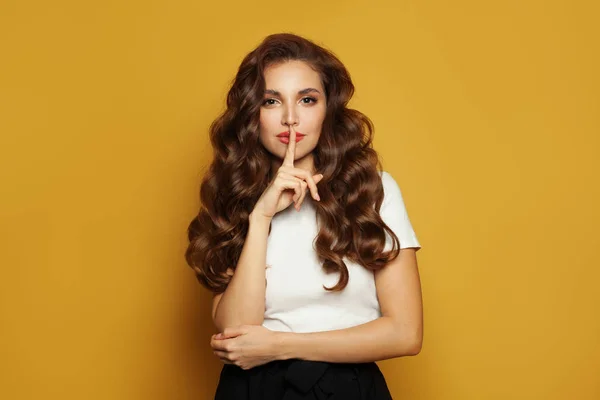 Mooi jong model vrouw houdt voorvinger op lippen — Stockfoto