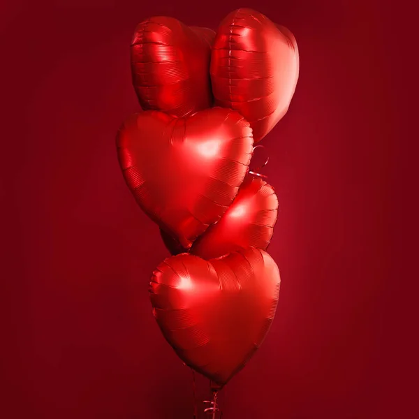 Composición perfecta de globos de corazón rojo en tarjeta roja brillante — Foto de Stock