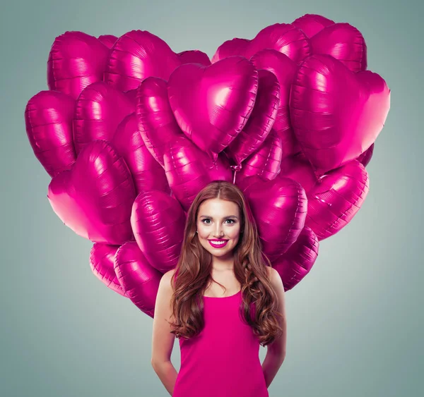 Belle jeune femme au grand cœur faite de ballons roses — Photo