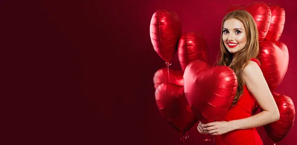 Smiling girl with red balloons on red banner background — Stock Photo, Image