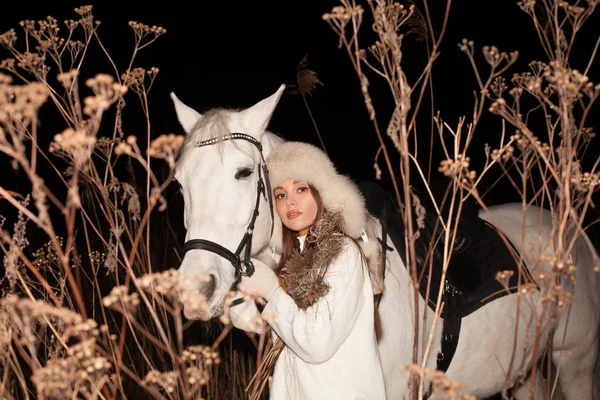 Winter woman and white horse outdoors at night — 스톡 사진