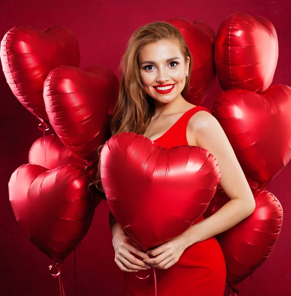 Portrait of beautiful young woman with red heart balloons — Stock Photo, Image