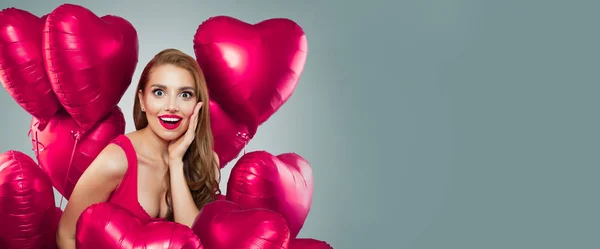 Young attractive woman holding vivid pink heart balloons on gray — Stock Photo, Image