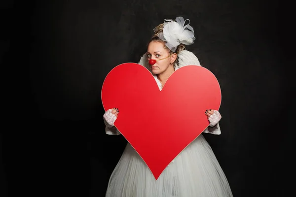 Performer woman clown holding white empty heart banner — Stock Photo, Image