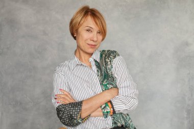 Mutlu gülümseyen orta yaşlı kadın gri arka planda
