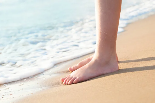 Fötter av en ung kvinna på tropisk strand. Surf hav och surise — Stockfoto