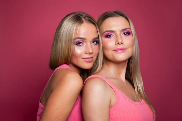 Jolis modèles avec un maquillage parfait sur fond rose — Photo