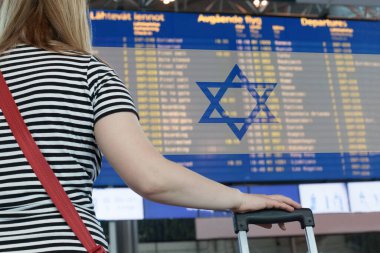 Woman looks at the scoreboard at the airport. Select a country Israel  for travel or migration.