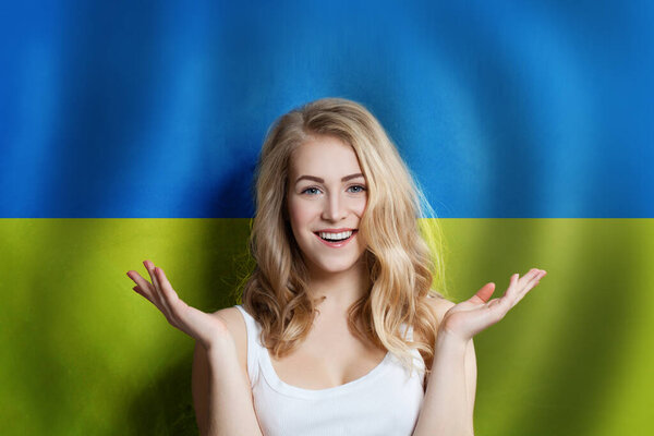 Surprised cute happy girl with Ukrainian flag background. Travel