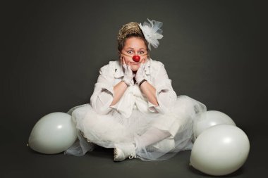 Gri arka planda kadın palyaço, stüdyo resmi. Performans Aktörü, Beyaz Palyaço Karakteri