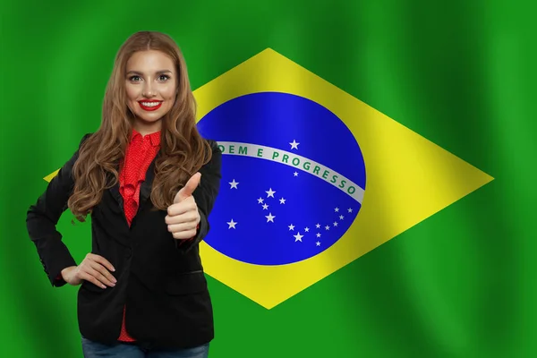 Happy Tmavovláska Palcem Nahoru Vystupují Proti Pozadí Vlajka Brazílie — Stock fotografie
