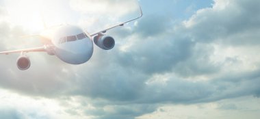 Gökyüzünde modern bir uçak, güneş ışığı. Kokpitin ön görüntüsü