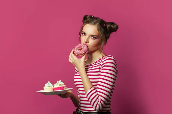Wanita Makan Donat Pada Warna Warni Latar Belakang Pink — Stok Foto