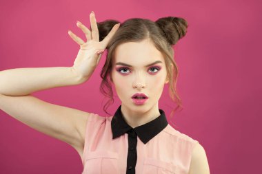 Parlak pembe arka planda moda makyajlı güzel bir kadın.