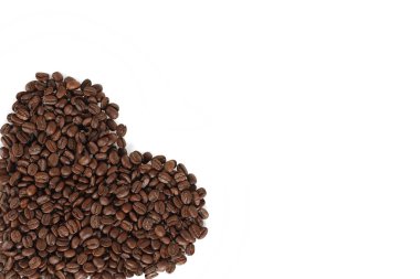 Beyaz arka planda kahve çekirdekleri olan kalp.