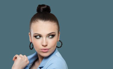 Mükemmel kadın esmer, mavi arka plana bakıyor.