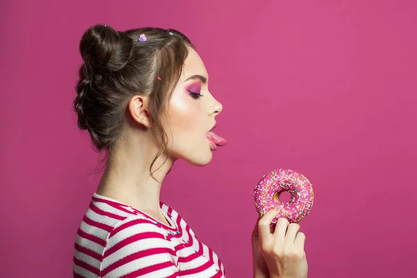 Güzel Genç Bir Kadın Canlı Pembe Arka Planda Donut Yalıyor — Stok fotoğraf