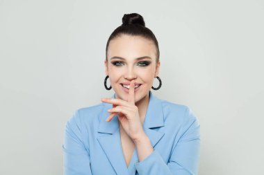 Sessizlik hareketi. Genç, güzel moda kadın esmer, parmakları dudaklarına yakın.