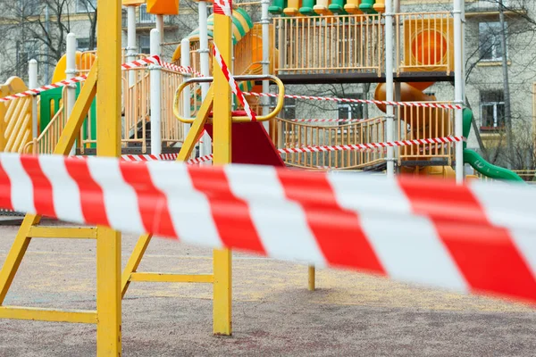 Empty playground. Playground closed for quarantine Covid-19 and blocked red warning tape. Stay home, please