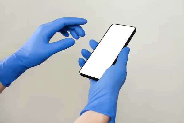 Doktor Beyaz Arka Planda Akıllı Telefon Kullanarak Tıbbi Eldiven Takıyor — Stok fotoğraf