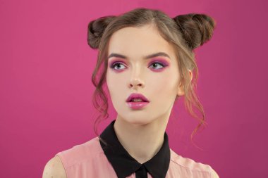 Genç ve güzel bir yüz. Renkli pembe arka planda moda makyajlı güzel bir kadın.