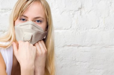 Young woman wearing protective medical mask on white background clipart