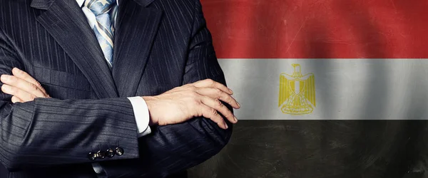 Crossed arms on Egyptian flag background, business, politics and education in Egypt concept