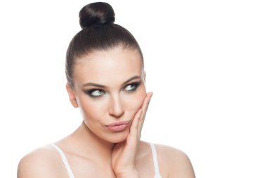 Güzel bir kadın beyaz arka planda izole edilmiş bir şekilde düşünüyor ve bakıyor, güzel bir yüz ifadesi var. 