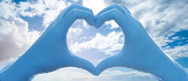 Coração Construir Mãos Médico Luvas Médicas Céu Azul Com Nuvens — Fotografia de Stock