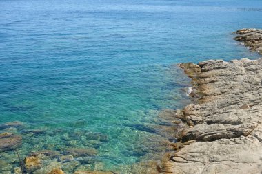 Kayalık kıyı ve deniz berrak mavi suyla