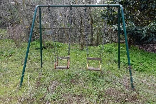 Oxidado columpios abandonado parque infantil —  Fotos de Stock