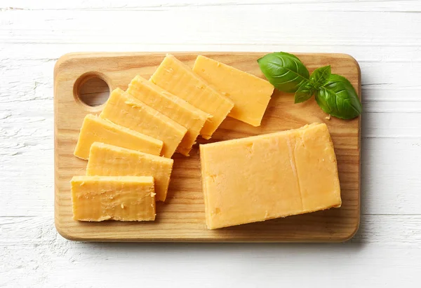 Piece and slices of cheddar cheese — Stock Photo, Image