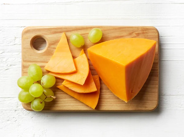 Pedaços e fatias de queijo cheddar — Fotografia de Stock