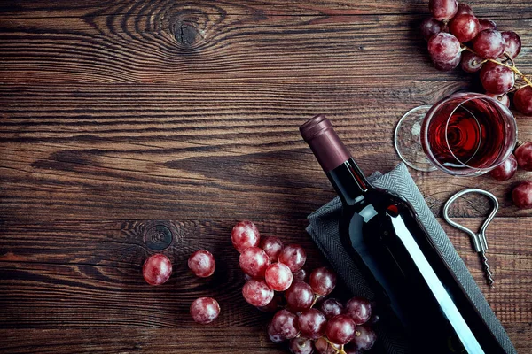 Láhve a sklenice červeného vína a hroznů — Stock fotografie
