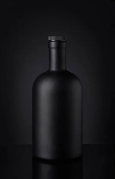 Bouteille de whisky noir sur fond sombre — Photo
