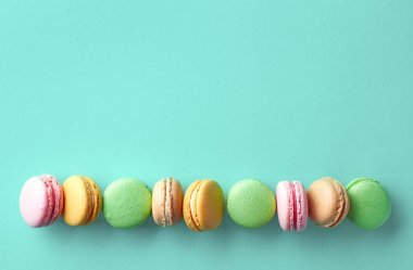 Mavi arka plan üzerinde renkli Fransız macarons