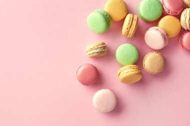 Pembe bir arka plan üzerinde renkli Fransız macarons